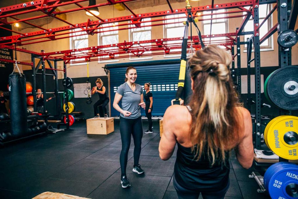 Vrouw bezig met fitness onder toezicht van personal trainer